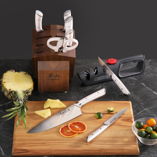 
                    
                      Knife block set with six knives and scissors in acacia wood block, two knives on cutting board with sliced citrus and pineapp
                    
                  