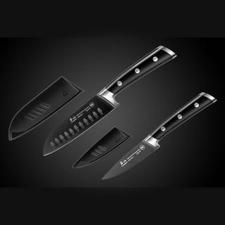 
                    
                      Two black chef knives with silver rivets and matching blade covers on a dark gradient background.
                    
                  