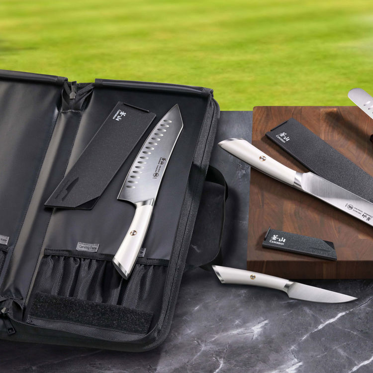 Six-piece BBQ knife set with white handles, black knife bag, and sharpening stones on a marble surface and wooden board.