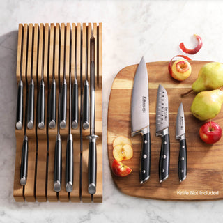 
                    
                      Bamboo knife organizer with 15 slots holding knives, next to a cutting board with three knives and assorted fruit.
                    
                  
