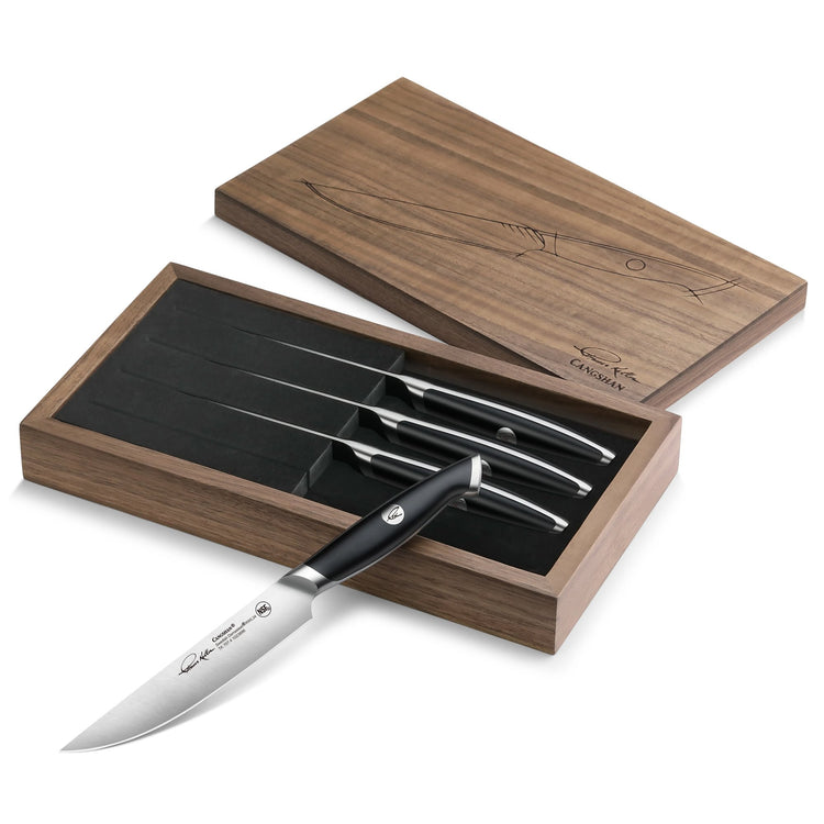 Four black-handled steak knives with stainless steel blades in a walnut storage box with a sliding lid.