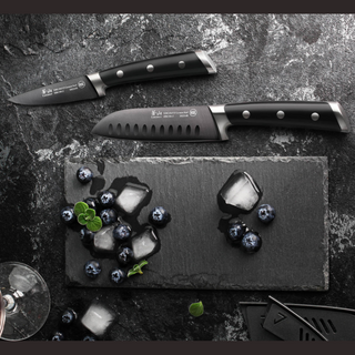 
                    
                      Two black-handled kitchen knives placed on a dark surface near blueberries and melting ice cubes on a slate board.
                    
                  