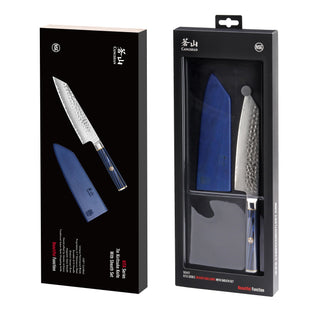 
                    
                      KITA Series 7-inch Kiritsuke knife with blue sheath and hammered blade in black retail packaging.
                    
                  