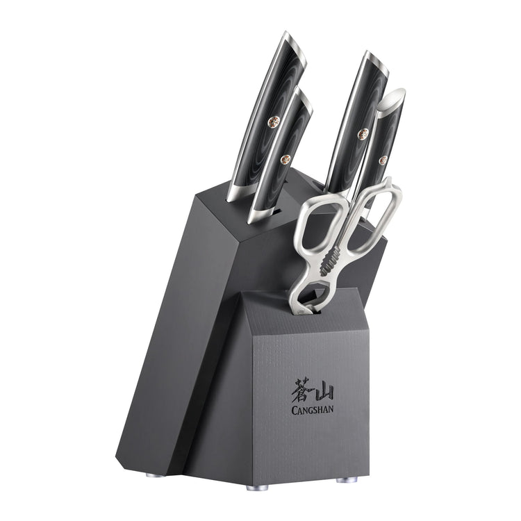 Six-piece knife set with black handles and stainless steel scissors in a black angled block labeled Cangshan.