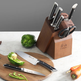 
                    
                      Knife block set with six knives and scissors, two knives on a cutting board with sliced green bell pepper.
                    
                  