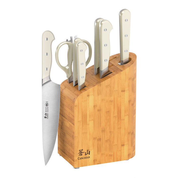 Bamboo knife block holding four knives with white handles and a pair of scissors.