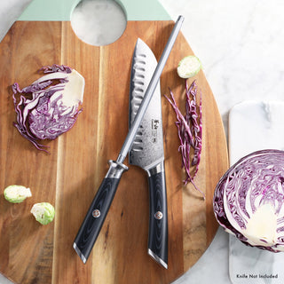 
                    
                      9-inch honing steel with black handle resting on a wooden cutting board next to a chef's knife and cut red cabbage.
                    
                  