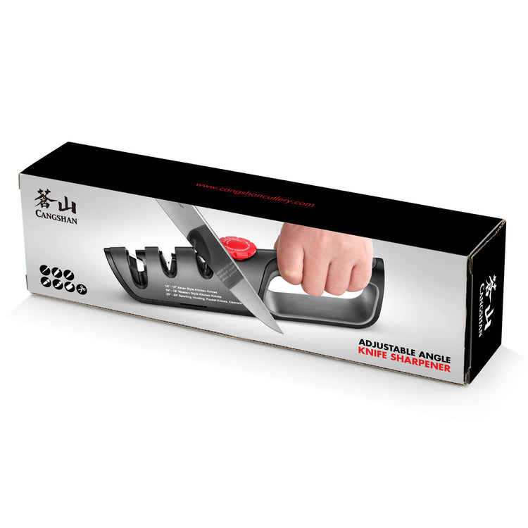 Hand holding a black knife sharpener with three slots and a red adjustment dial, sharpening a knife blade.