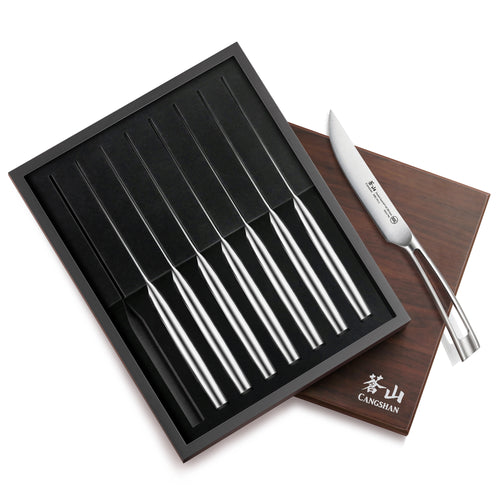Eight straight edge steak knives with stainless steel handles in a black tray, next to a wooden box with white logo.