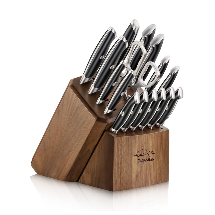 Wooden knife block holding a set of knives and two metal peelers with black handles.