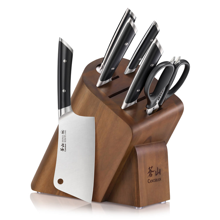 Wooden knife block holding five knives with black handles and a pair of kitchen scissors.