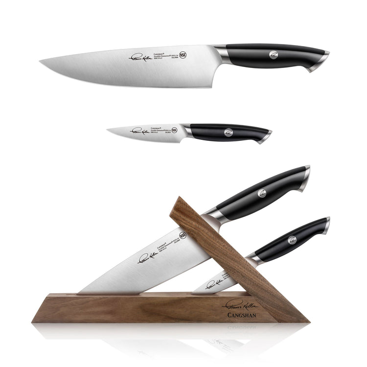 Three black-handled knives with stainless steel blades, two displayed above and one in a wooden triangular knife block.