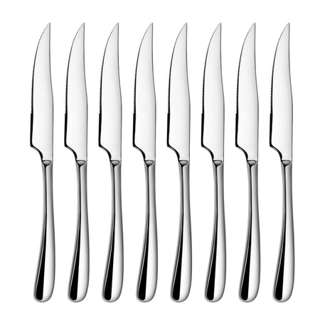 Eight stainless steel steak knives with serrated blades and polished handles arranged in a row.