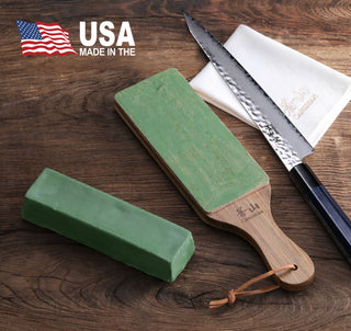 
                    
                      Green honing polish compound bar and paddle with wooden handle next to a serrated knife and white cloth on a wooden surface.
                    
                  