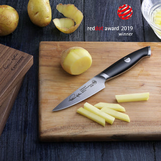 
                    
                      3.5-inch paring knife with black handle on wooden cutting board, slicing peeled potatoes into sticks.
                    
                  