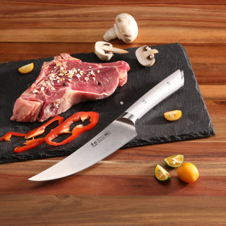 
                    
                      Boning knife with stainless steel blade and handle on a cutting board with raw steak, mushrooms, red pepper, and small citrus
                    
                  