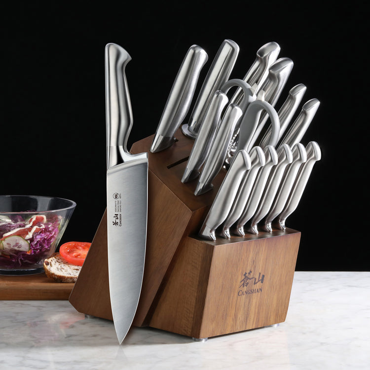 17-piece knife set with stainless steel blades and handles in a wooden block on a marble surface.