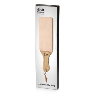
                    
                      Leather paddle strop with wooden handle and hanging loop, displayed on white packaging labeled "Leather Paddle Strop.
                    
                  