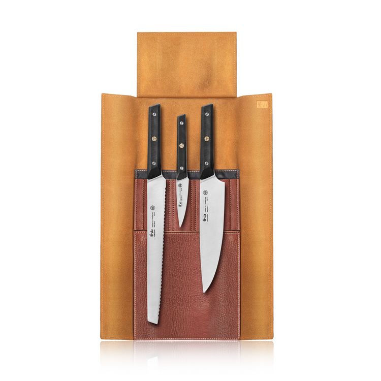 Three kitchen knives with black handles secured in a brown leather roll with three pockets, flap open.